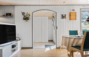BjerregårdにあるCozy Home In Hvide Sande With Wifiのリビングルーム(ダイニングテーブル、テレビ付)