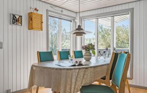 BjerregårdにあるCozy Home In Hvide Sande With Wifiのダイニングルーム(テーブル、椅子付)