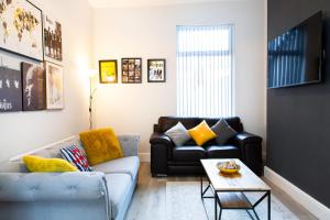 a living room with a couch and a table at 4 Bedrooms Spacious House With 2 Bathrooms Free Parking - sleeps up to 10 guests in Liverpool