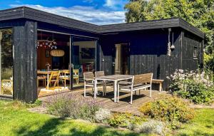 a black house with a table and chairs on a deck at Beautiful Home In Vejby With Wifi in Vejby