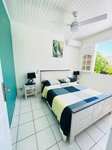 um quarto com uma cama e uma janela em VILLA C'MARGOT em Marigot