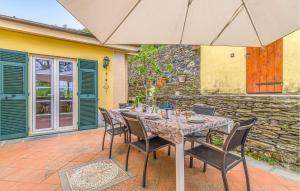 a table with chairs and an umbrella on a patio at Lovely Apartment In Cogorno With Wifi in Cogorno