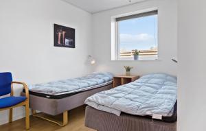 - 2 lits dans une chambre avec une chaise et une fenêtre dans l'établissement Beautiful Home In Sydals With Sauna, à Skovmose