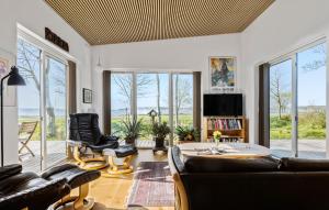 uma sala de estar com um sofá, cadeiras e janelas em Gorgeous Home In Haderslev With Wifi em Haderslev