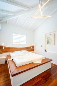 a white bedroom with a bed with a wooden headboard at Villa 0.5 in Saint-François +47 photos