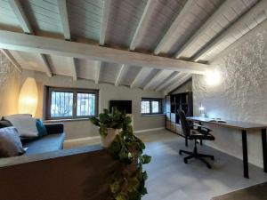 a living room with a couch and a desk at Casa Pedrarias in Lavena Ponte Tresa