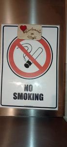 un cartello su un muro con un cartello di divieto di fumo di Appartamento ai Tigli a Noale