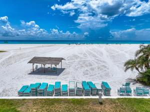 a group of chairs and a picnic table on a beach at Jamaica Royale Beachfront Tower in Siesta Key