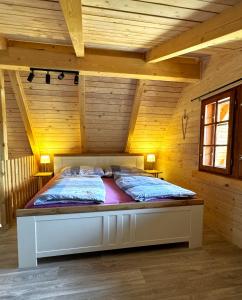 ein Schlafzimmer mit einem Bett in einem Holzzimmer in der Unterkunft Chata RESTART in Jevíčko