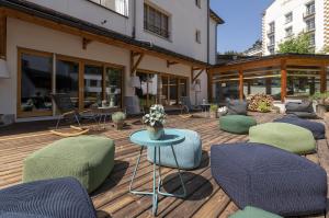 eine Terrasse mit Stühlen und einem Tisch auf einer Holzterrasse in der Unterkunft Apartment Schweizerhof 402 für zwei-Lenzerheide in Lenzerheide