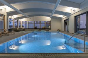 ein großer Pool mit blauem Wasser in einem Gebäude in der Unterkunft Apartment Schweizerhof 402 für zwei-Lenzerheide in Lenzerheide