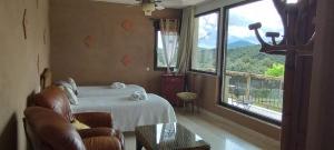 a hotel room with a bed and a large window at Casa Rural Finca Los Pajaros cerca de Puy du fou in Navahermosa