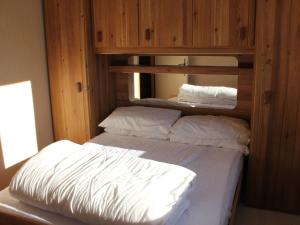 1 cama con sábanas blancas y almohadas en una habitación en Appartement Châtel, 3 pièces, 6 personnes - FR-1-676-62, en Châtel