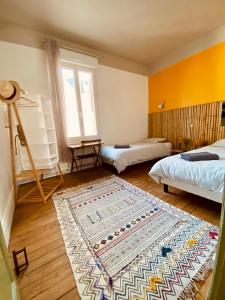 a room with two beds and a rug on the floor at Les 3 Graces, Cayeux-sur-mer, agréable maison in Cayeux-sur-Mer