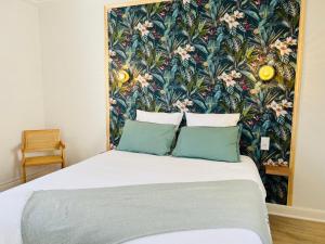 a bedroom with a large bed with a floral wallpaper at Perpignan gare calme spacieux jolie vue netflix in Perpignan