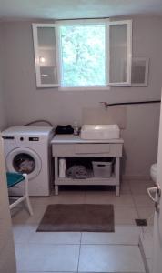 uma pequena casa de banho com uma máquina de lavar roupa e um lavatório em Rustic and Remote Stone Cottage em Arta