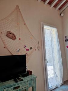 un soggiorno con TV a schermo piatto e finestra di Serra di mare casa con giardino a Livorno