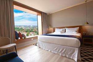 a hotel room with a large bed and a large window at Novotel Santa Cruz De La Sierra in Santa Cruz de la Sierra