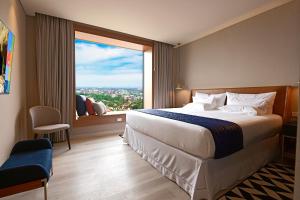 a hotel room with a large bed and a large window at Novotel Santa Cruz De La Sierra in Santa Cruz de la Sierra