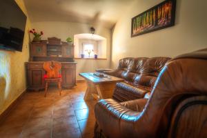 a living room with a leather couch and a table at Stara sončna hiša in Radovljica