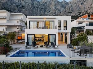 a house with a swimming pool in front of a house at Ferienhaus Komplex - Villa Oliver - Makarska Exklusiv in Veliko Brdo