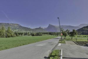 an empty road in a field with mountains in the background at Appartement Samoens l'Etelley in Samoëns +2 photos