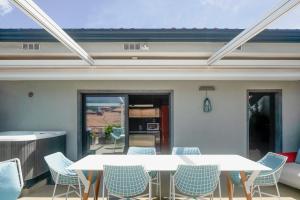 a patio with white tables and blue chairs at Casa Rebecca in Riposto