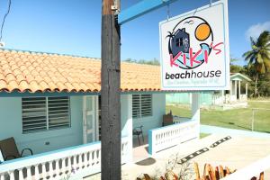 una casa con un cartel para una casa de playa en Kikis Beach House, en Fajardo