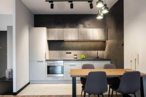 een keuken met een houten tafel en een aantal stoelen bij Apartament Augustynika in Dąbrowa Górnicza