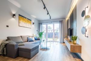 een woonkamer met een bank en een tafel bij Apartament Augustynika in Dąbrowa Górnicza