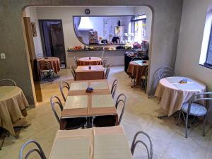 a restaurant with tables and chairs and a kitchen at Hotel Makuxis - Brigadeiro in São Paulo