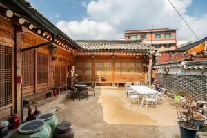 a patio of a house with a table and chairs at NamHyunDang - Hanok Korean Traditional House in Seoul