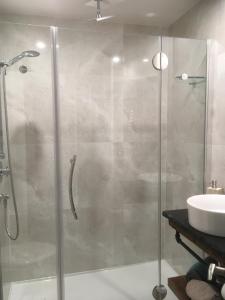 una ducha con una puerta de cristal junto a un lavabo en Au Pied de la Montagne CITQ29570Quatre, en Mont-Tremblant