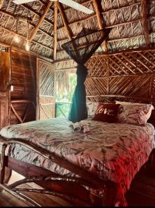 Un dormitorio con una cama con un jarrón. en Tropical Samana, en Santa Bárbara de Samaná