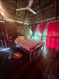 1 dormitorio con 1 cama en una habitación con cortinas rojas en Tropical Samana, en Santa Bárbara de Samaná