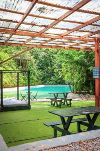 un refugio de picnic con mesas de picnic y una piscina en Tropical Samana, en Santa Bárbara de Samaná