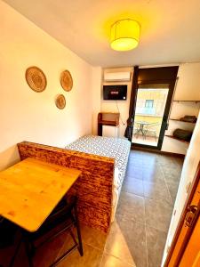 a room with a bed and a table and a window at MT Nuevos Apartamentos y Suites con baño privado in Mataró