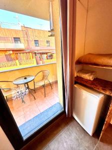 a view of a room with a table and a window at MT Nuevos Apartamentos y Suites con baño privado in Mataró