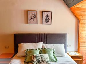 a bedroom with a bed with three pictures on the wall at Logu i Harushave in Theth
