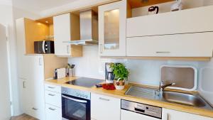 a kitchen with white cabinets and a sink at 54° Nord Wohnung 5 in Grömitz