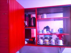 a red shelf with a woman in a kitchen at Pearl Furnished Home in Buloba