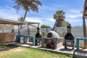 a outdoor oven in a yard with a fence at Rocca dei Tramonti Apartments in Punta Braccetto