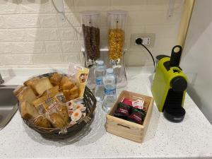- un comptoir avec un panier de pain et des bouteilles d'eau dans l'établissement Dimora Giuditta, à Brindisi