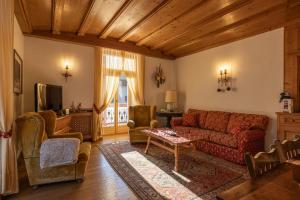 un soggiorno con divano rosso e sedie di Casa Ciclamino, direttamente sul Corso di Cortina dAmpezzo a Cortina dʼAmpezzo