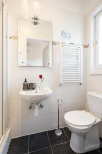 a white bathroom with a toilet and a sink at NEO Rooftop Home with AC in Budapest