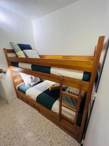 two wooden bunk beds in a room with a wall at Les Appartements De Lina - West city 2 - Self Check-In - in La Grande Motte