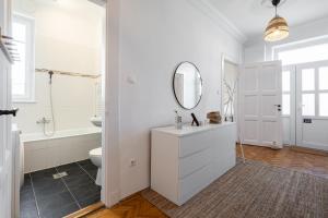 a white bathroom with a sink and a mirror at NEO Rooftop Home with AC in Budapest +16 photos