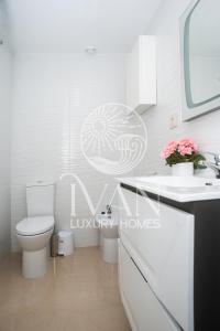 ein weißes Badezimmer mit Toilette und Waschbecken in der Unterkunft Casa Coral Ivan Luxury Homes 9ªPlta Sur 1ªLinea in Oropesa del Mar