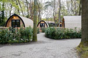 ein paar kleine Häuser in einem Wald in der Unterkunft Boslodges Veluwe in Nunspeet