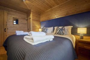 een slaapkamer met een bed met handdoeken erop bij Chiffchaff Lodge with Hot tub in Carlisle